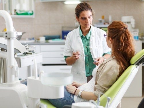 Dentist talking to a patient in dental chair