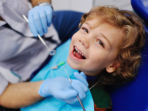 Young child laughing in dental chair