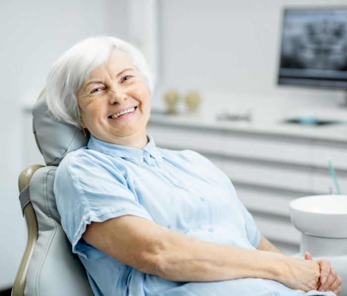 Senior woman in dental chair grinning