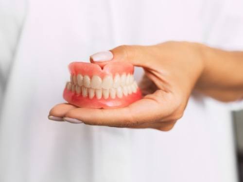 Dentist holding set of full dentures