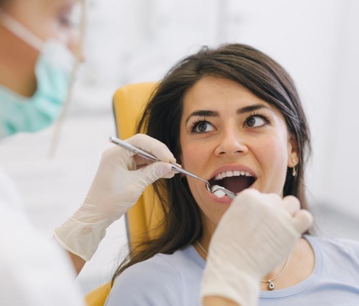 Dentist examining mouth of patient